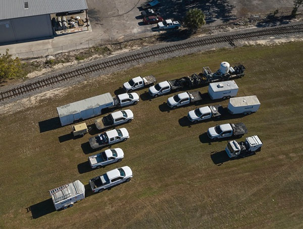 Taylor's Industrial Coatings trucks and trailers in a field